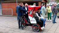 Ein Mann erklärt die Fahrrad-Rikscha der Malteser.